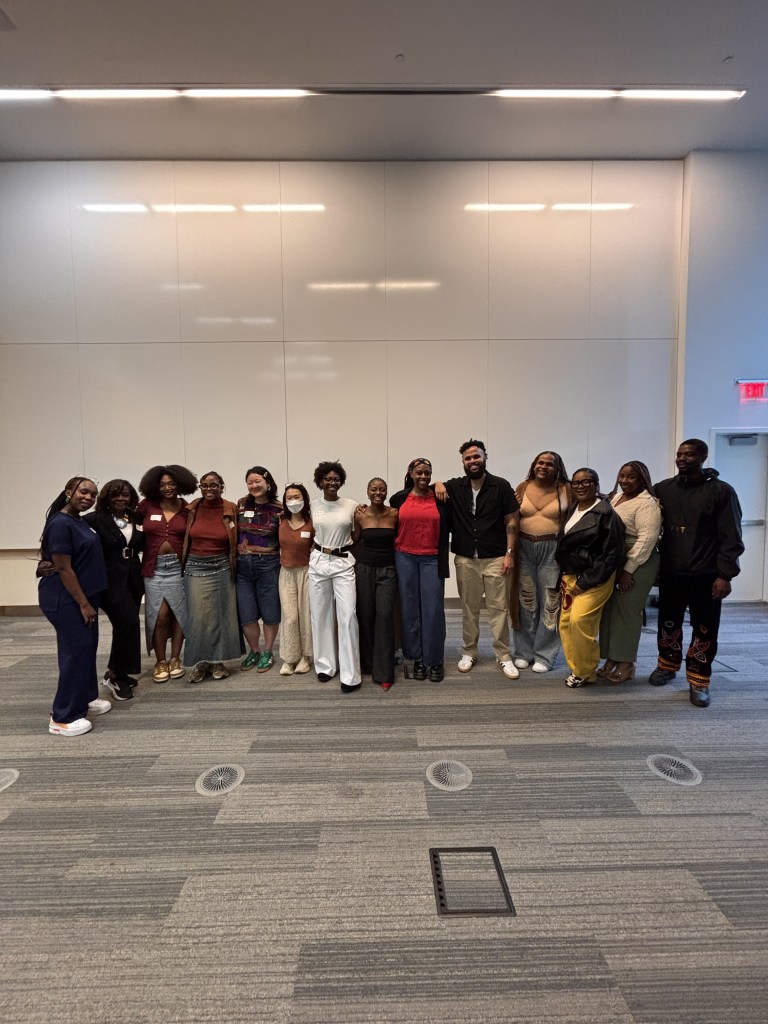 Group of 20 people standing and smiling for a picture